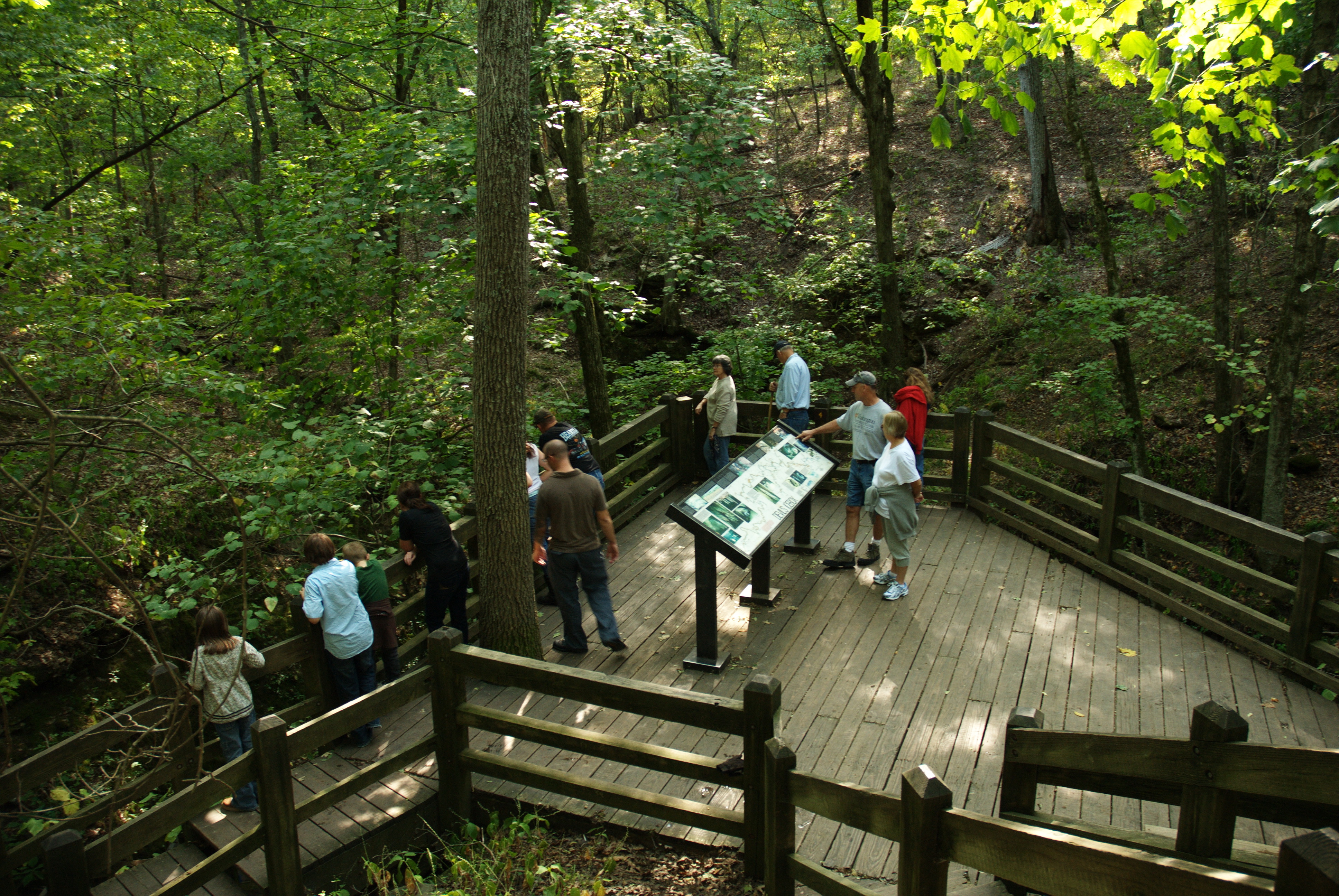 people looking at a display plaque for caves