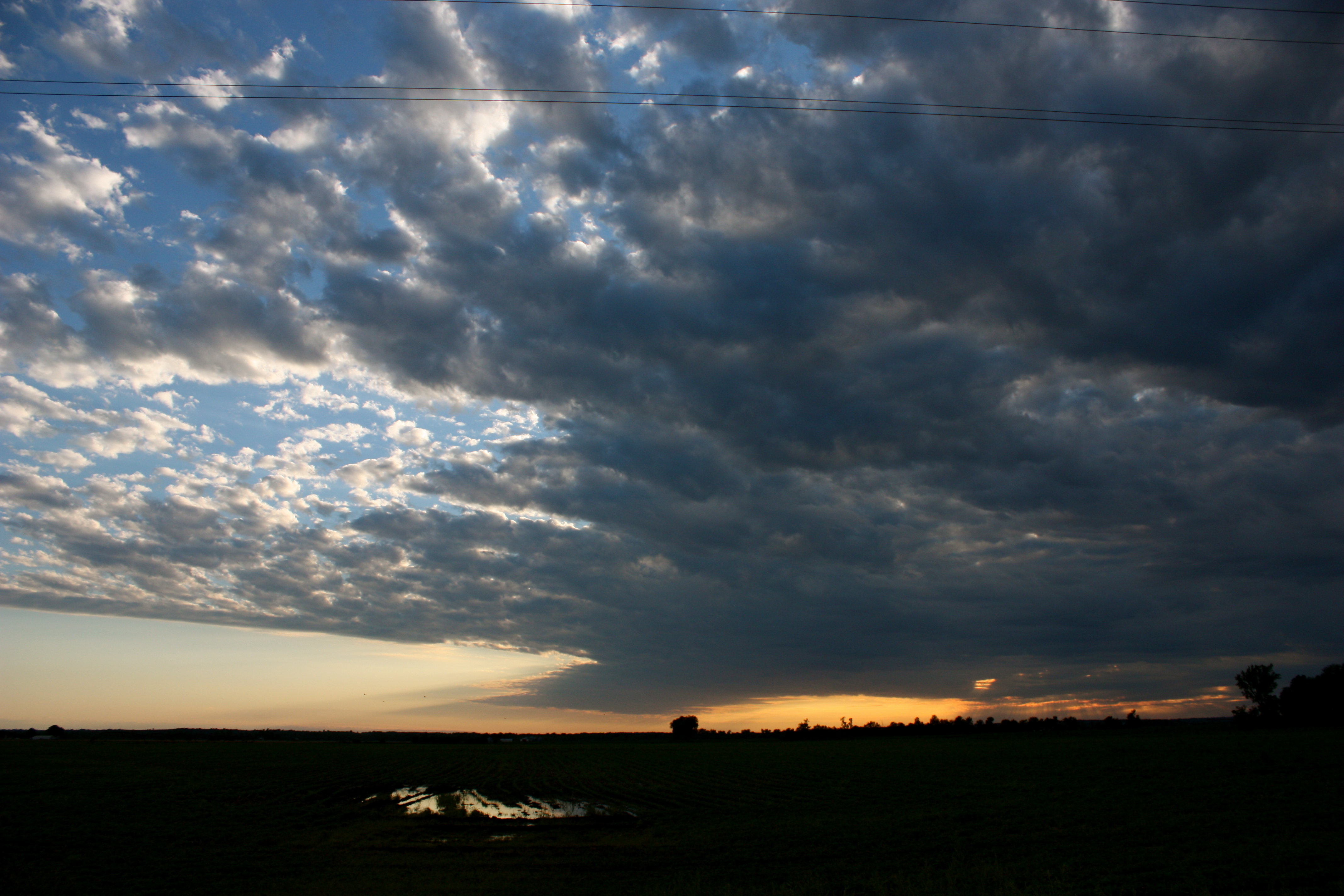 dark clouds rolling over the sky at sunset