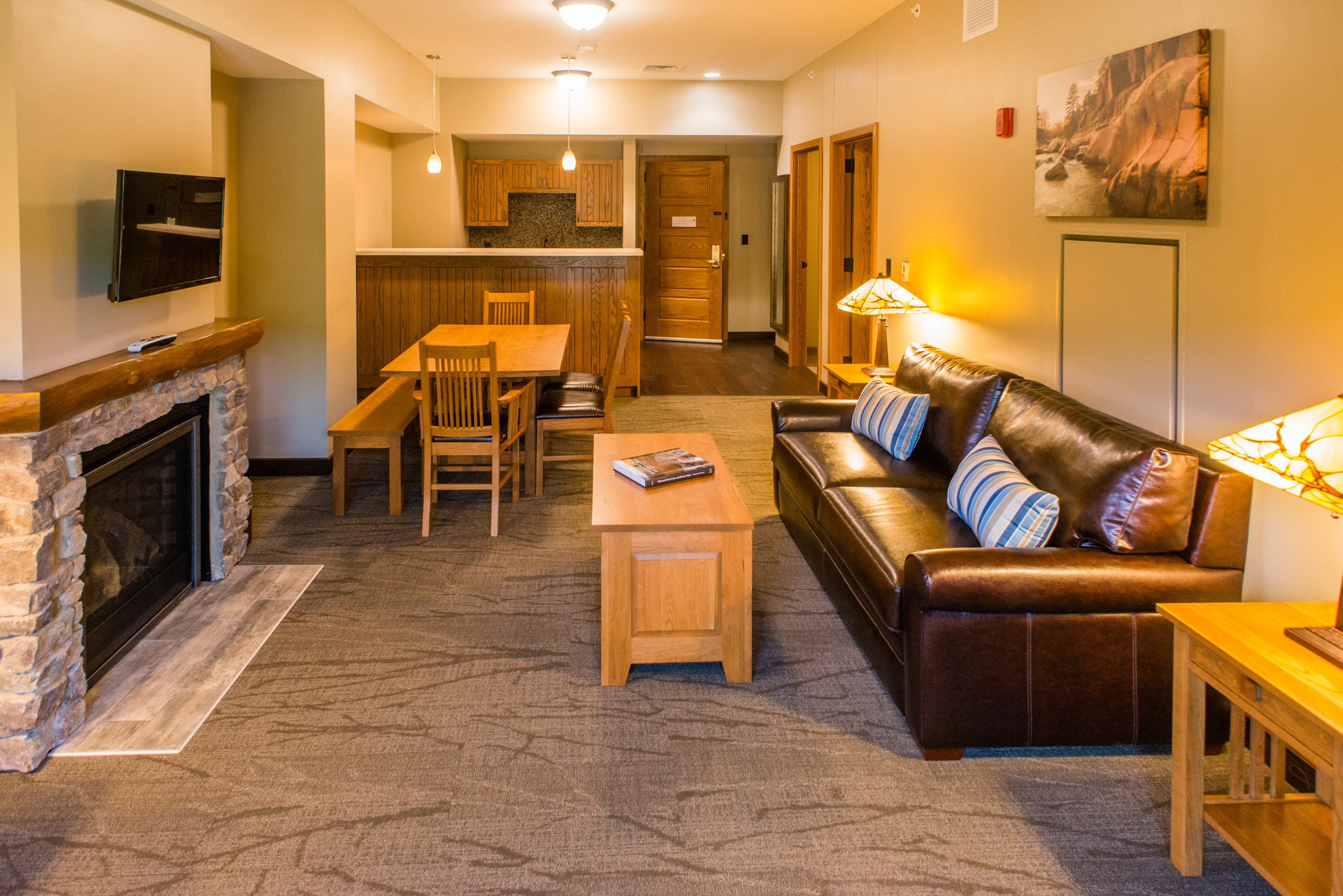 Living room with a leather couch, fireplace, and a tv