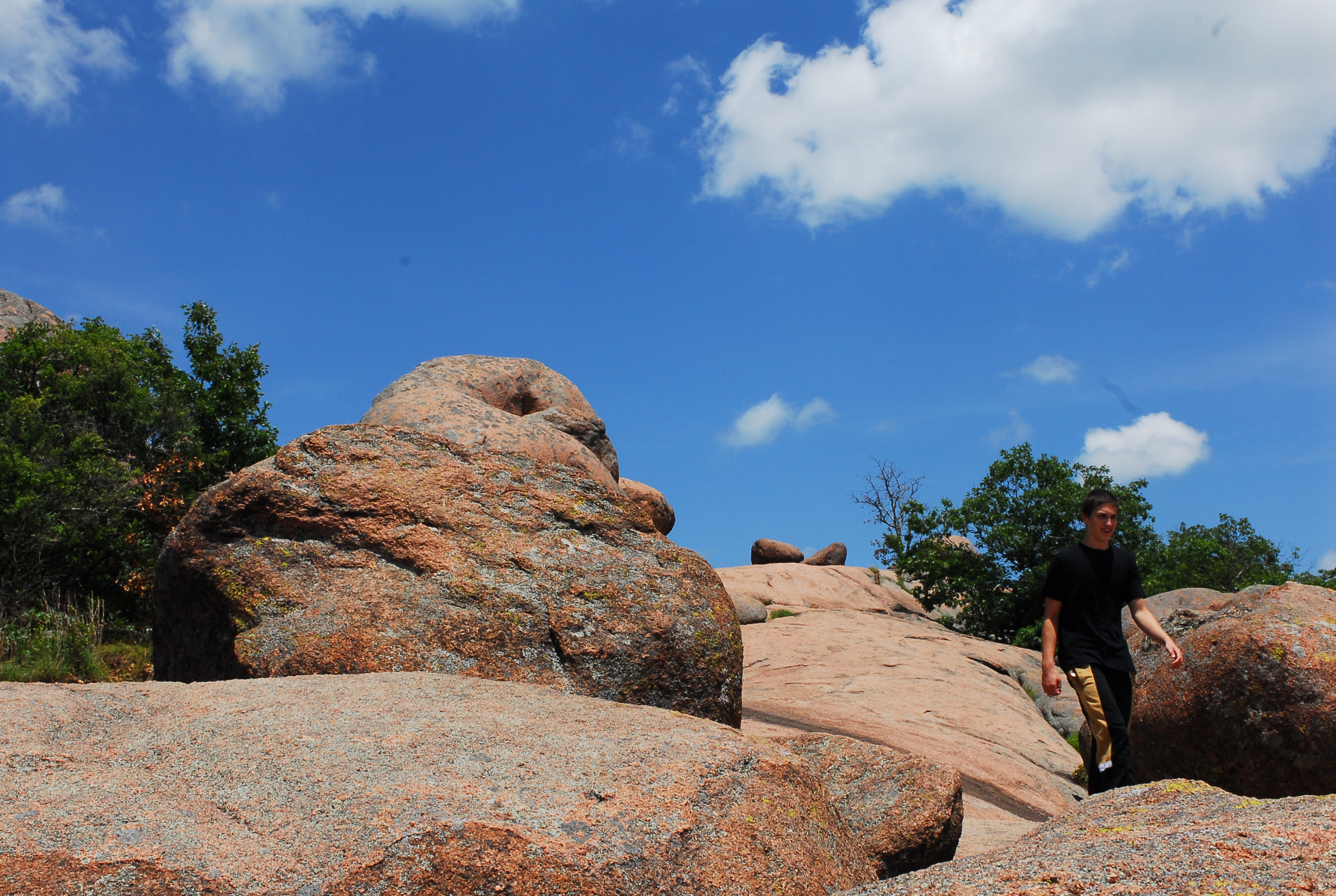 A person walking between red bolders