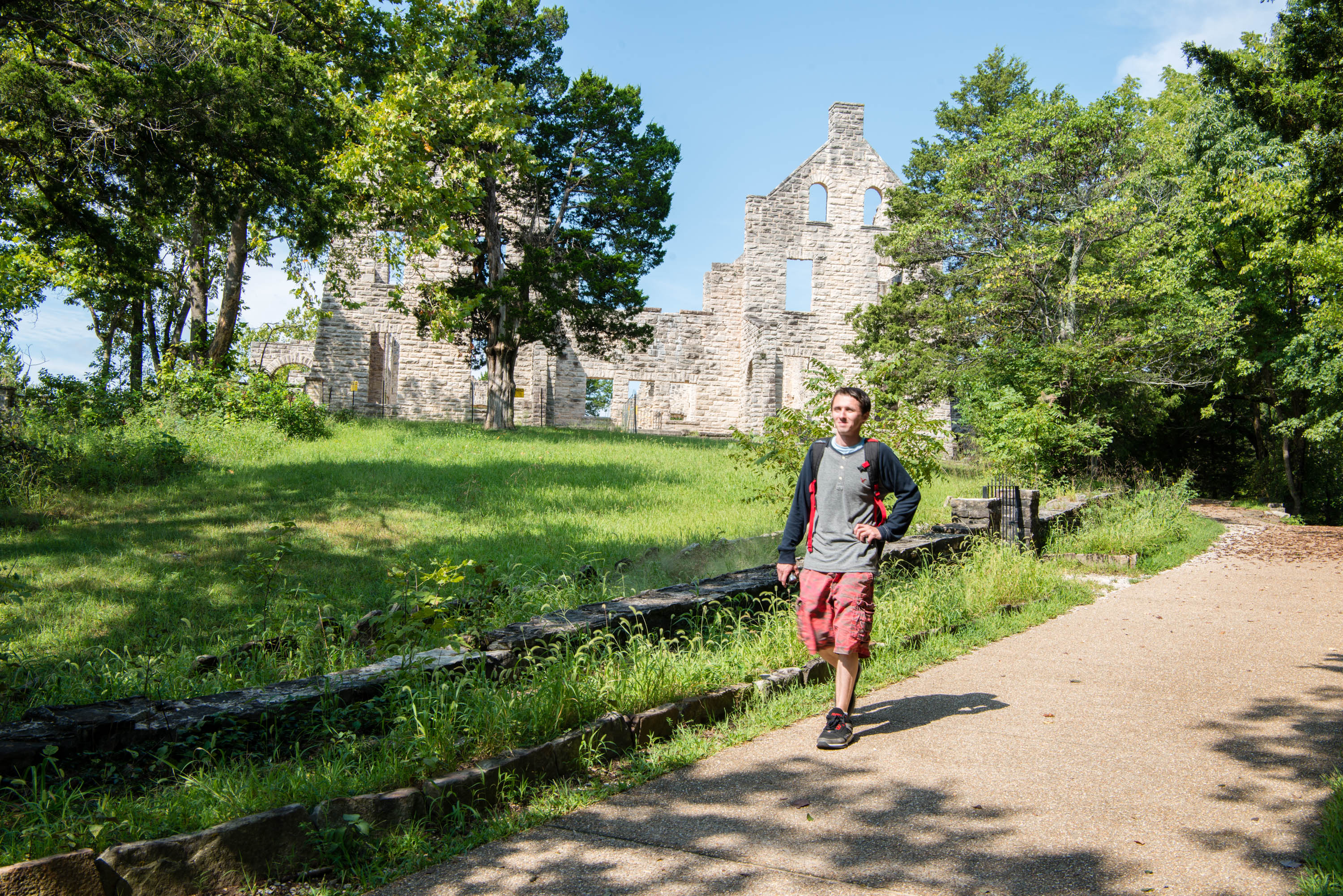 A man hiking in front of stone ruins