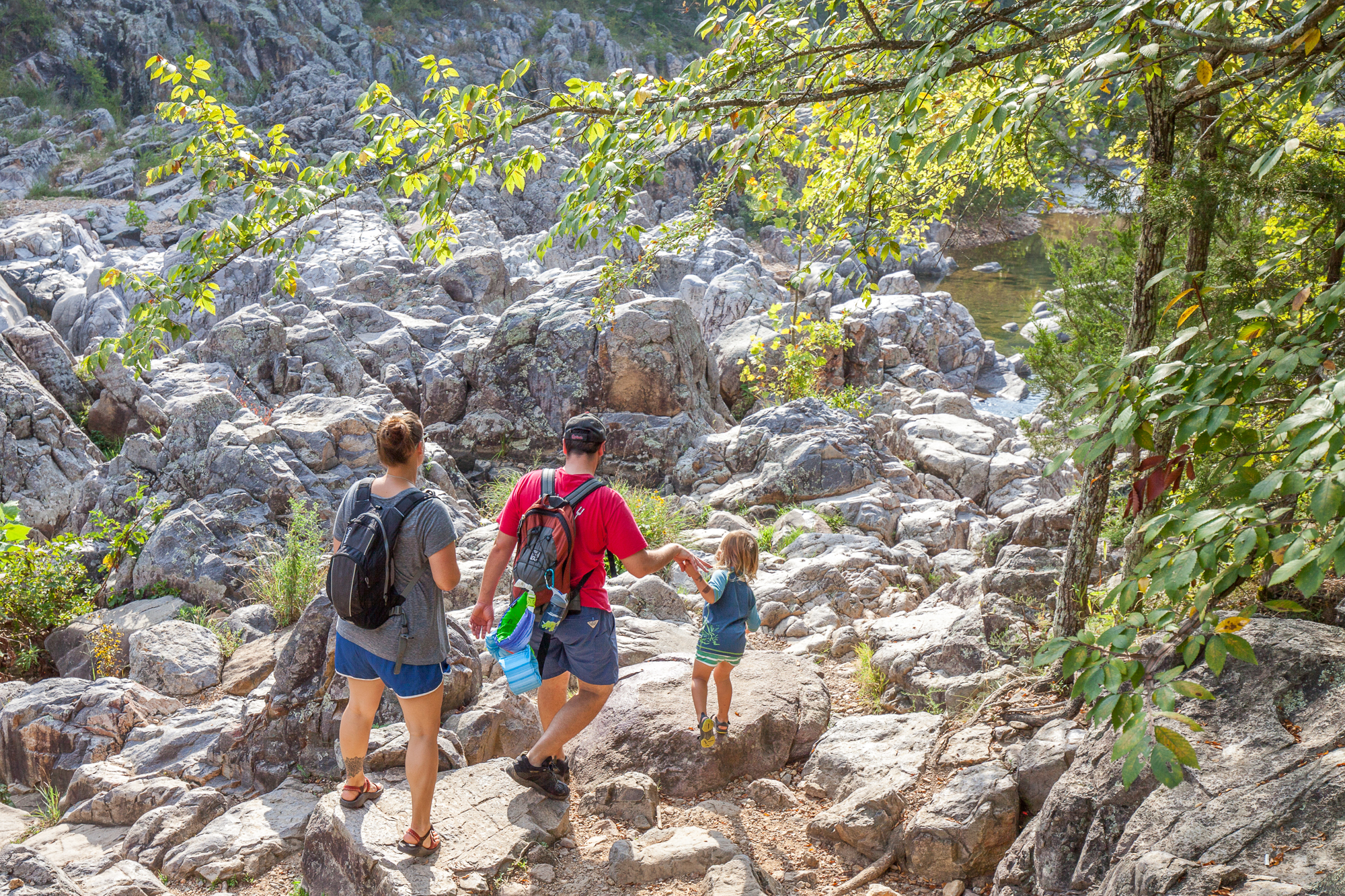 A family walking over rocks