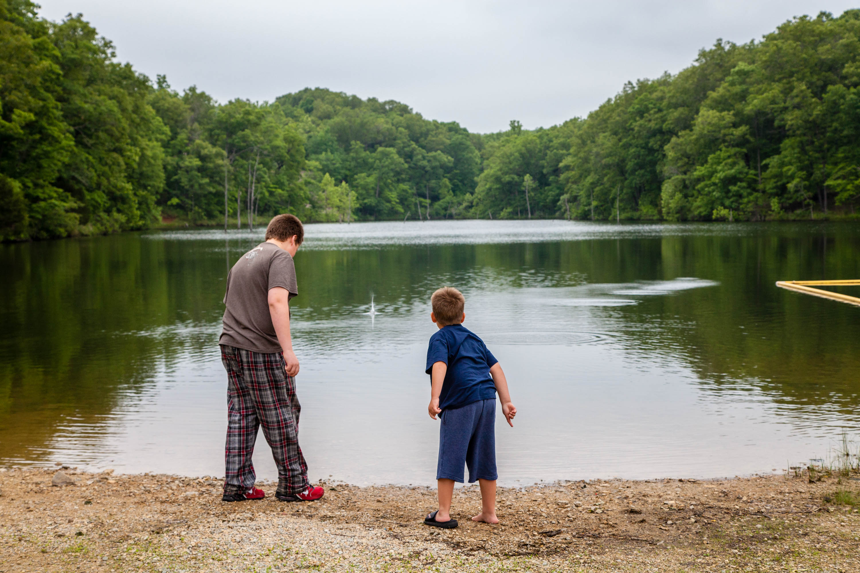 Two kids standing in front of a lake