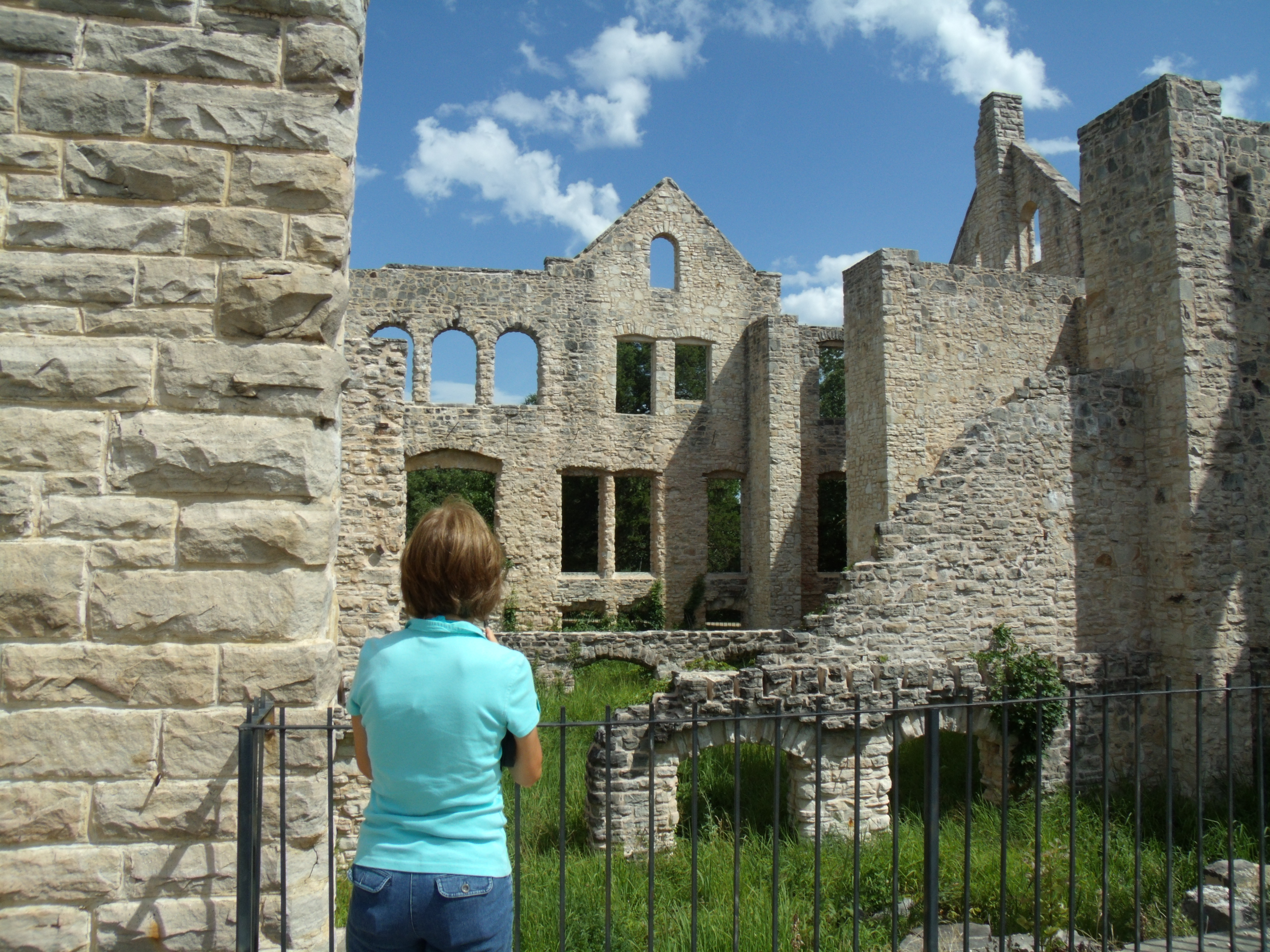 A woman standing in front of stone ruins