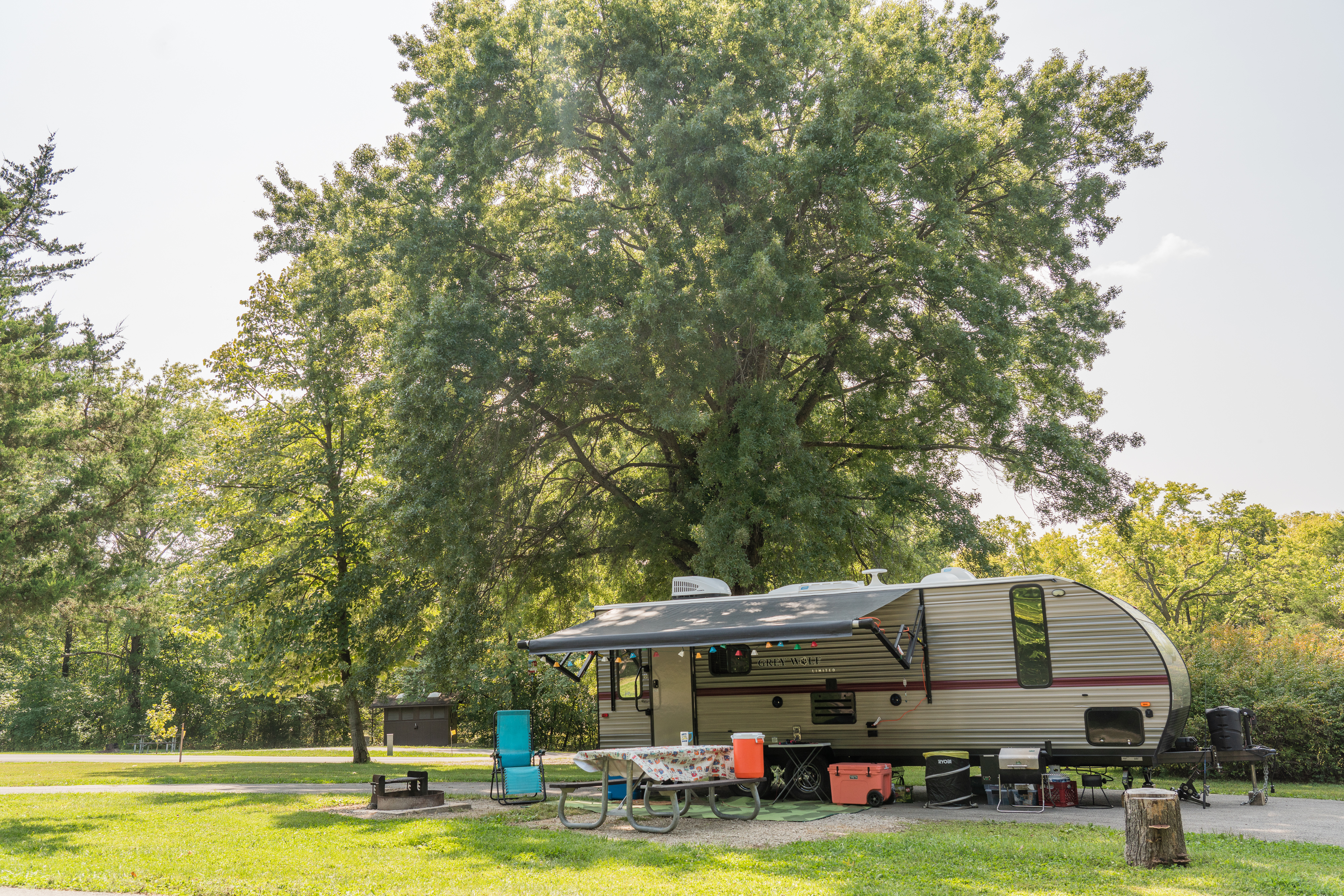 A picnic table set up beside a camper