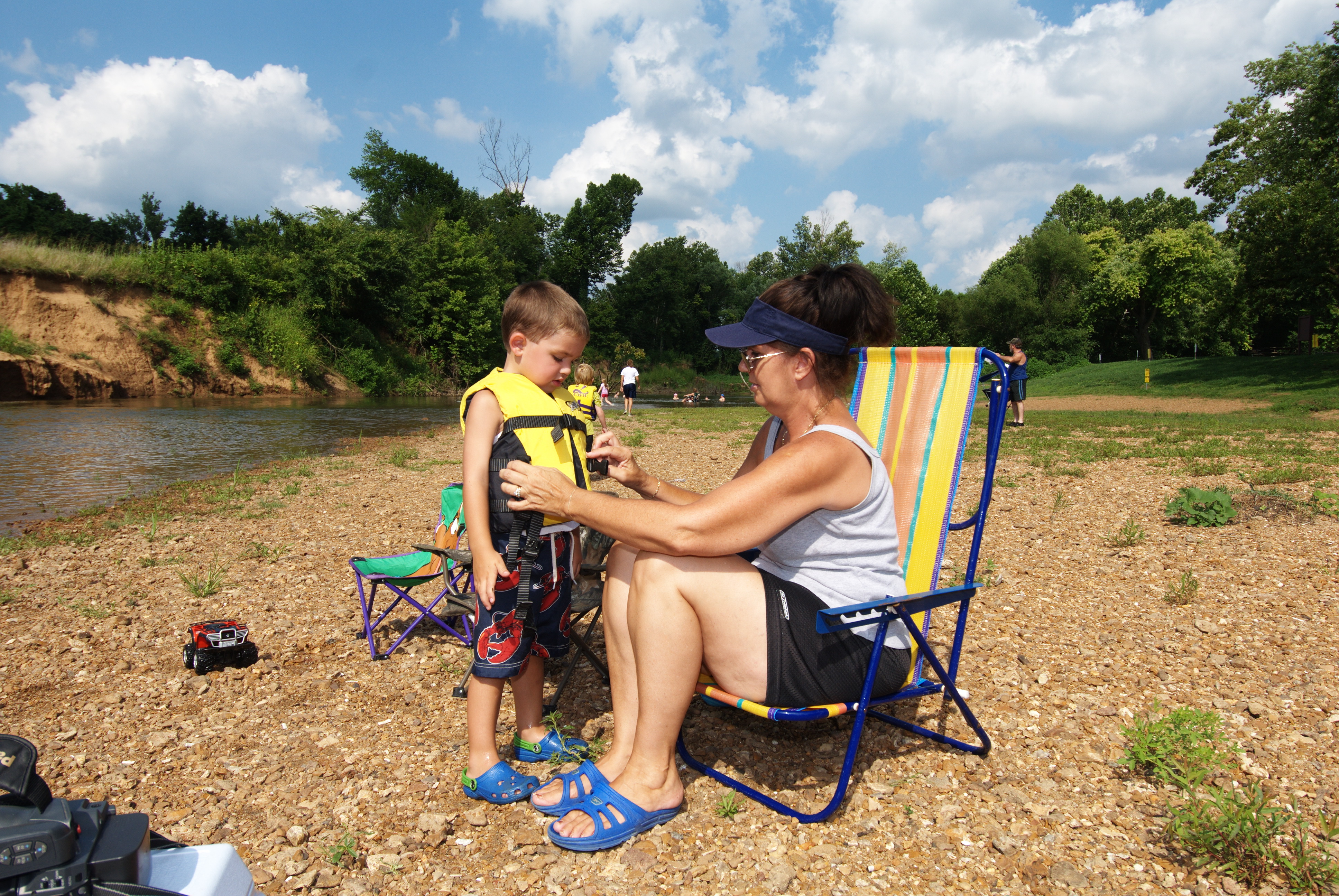 A woman helping a child into a life jacket