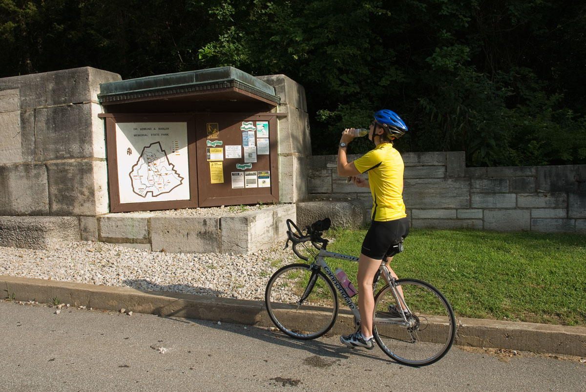 A person on a bike next to a trail map