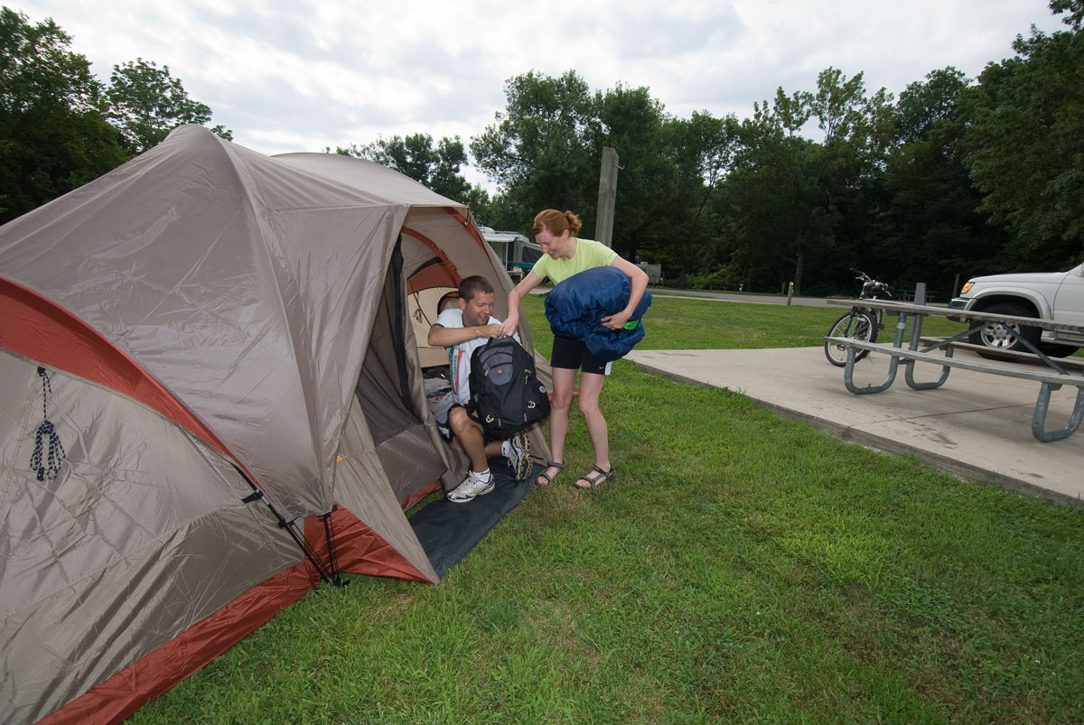 Two people moving bags into a tent
