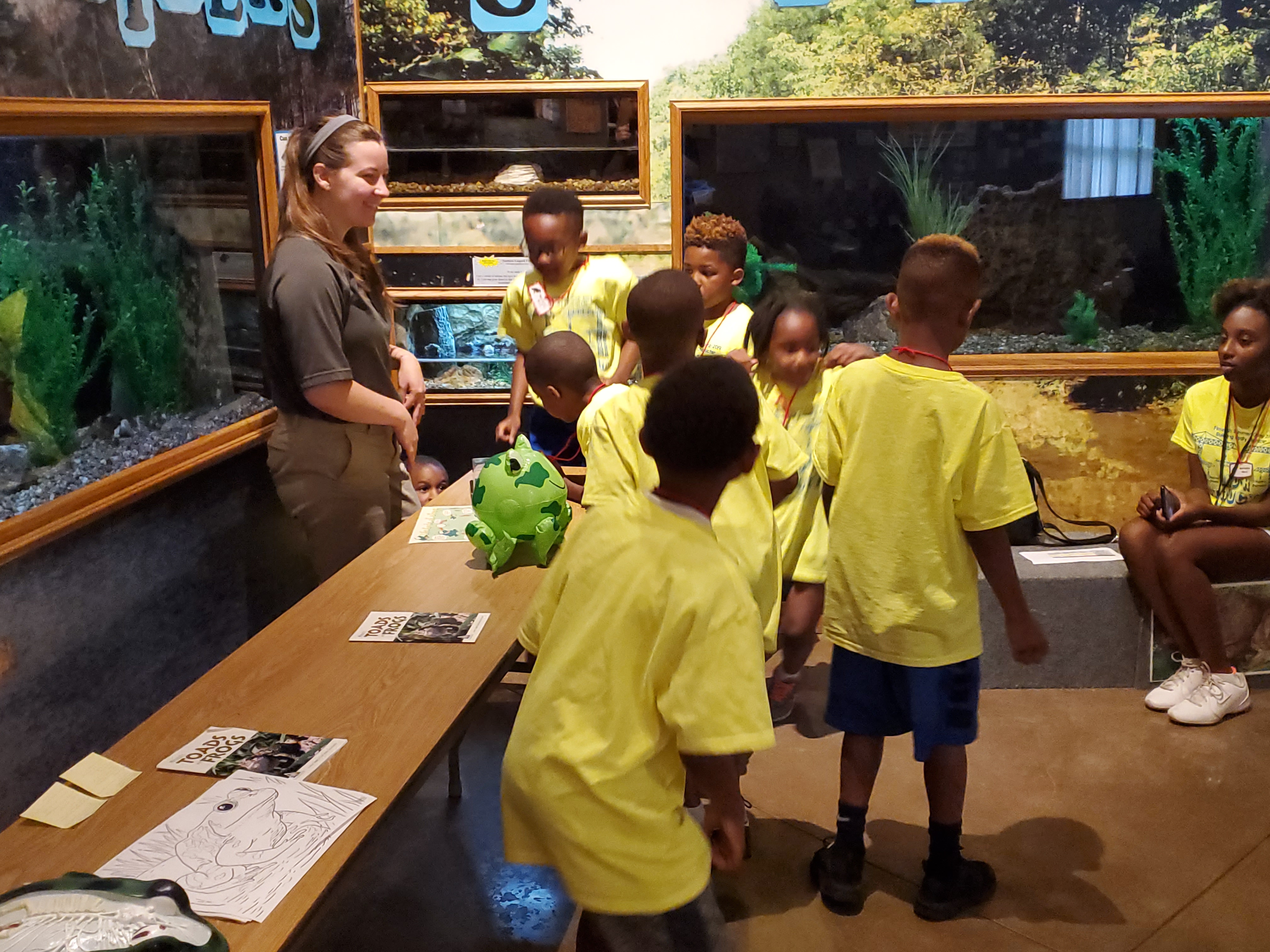 A group of school kids learning about frogs