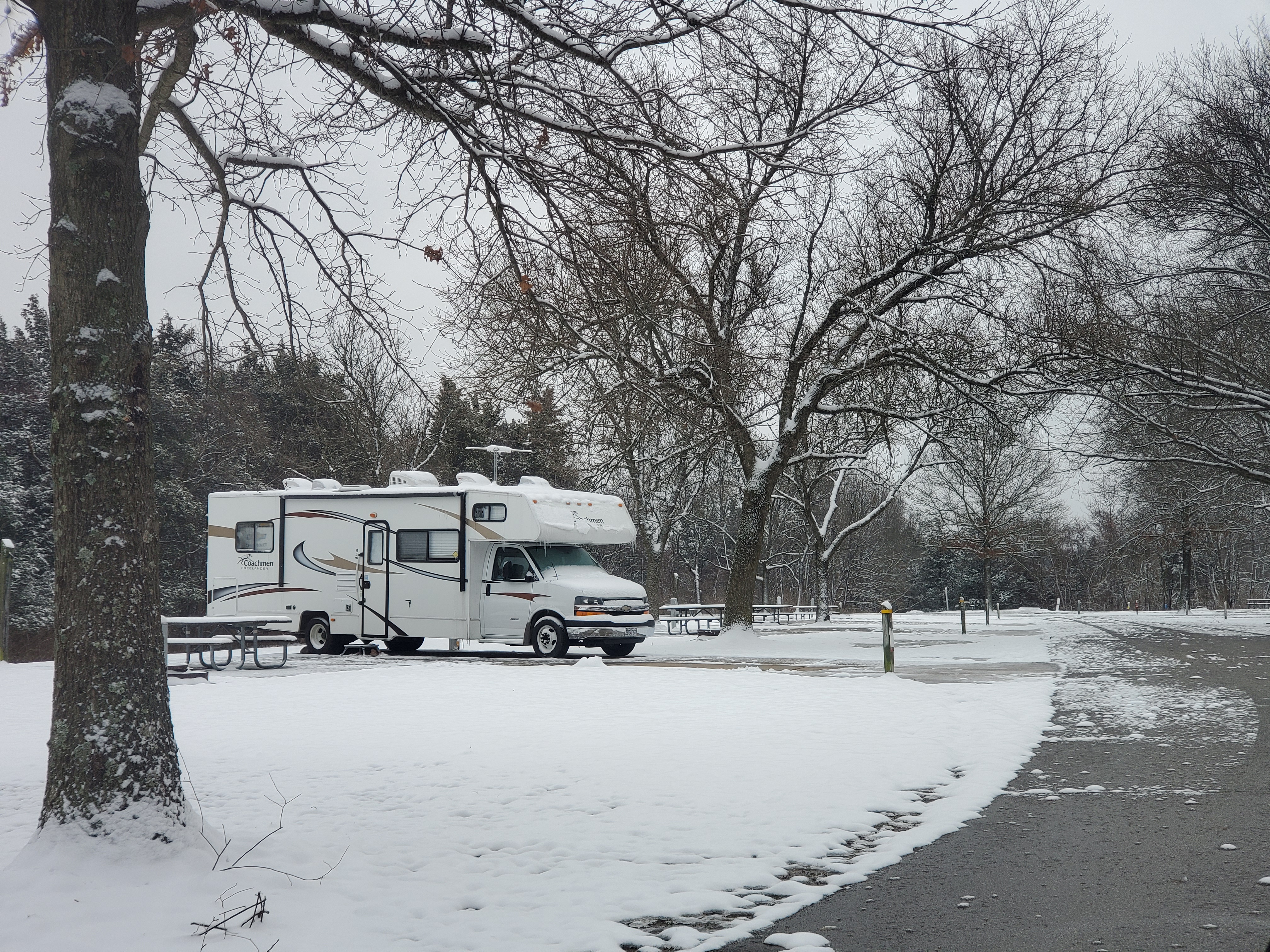 An RV parked at the park in the snow
