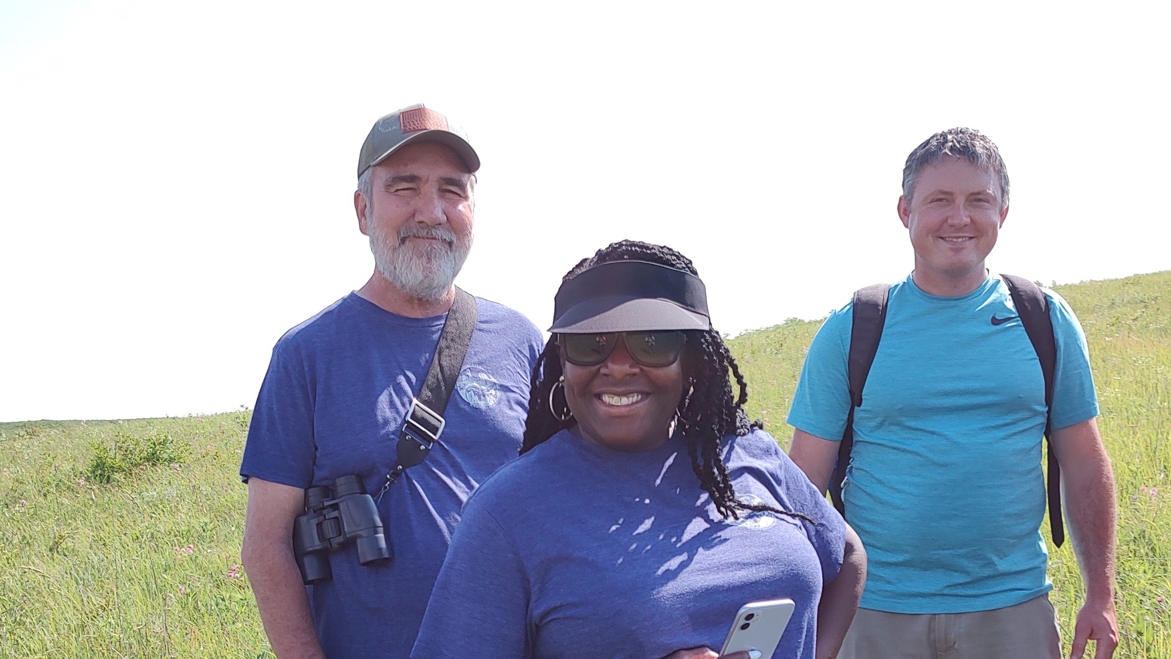Three people standing in a field