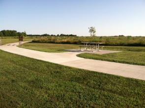 picnic table sitting along side a concrete pathway