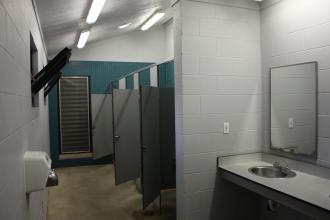 inside of showerhouse with 4 stalls, 1 sink, and a hand dryer