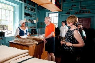 a tour guide dressed in perior attire talks with visitors