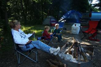 A family next to a campfire at a campsite