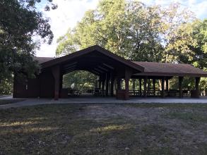 Open picnic shelter, with trash cans and a grill