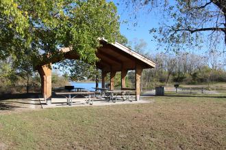 View of a covered picnic shelter by a lake