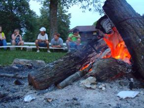 Kids sitting around a group fire ring.