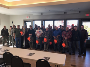 Hunters posing for a photo in a conference room