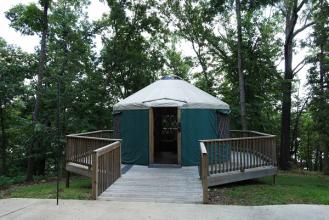 Exterior of a yurt situated on a wooden deck with railing.
