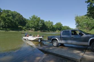a truck backed down on the boat ramp unloading a boat
