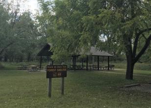 Open picnic shelter with forest shelter sign in foreground