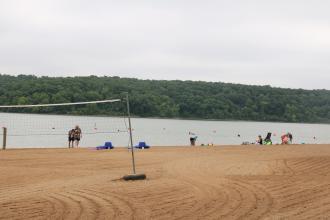 a volleyball net and people swimming in the lake