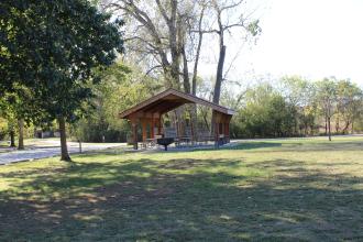 picnic shelter with a grill and several picnic tables