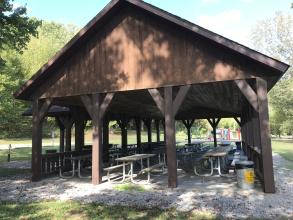 Large wooden shelter with playground in background