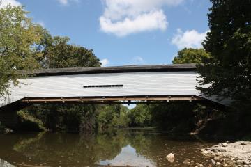 A white covered bridge over a river