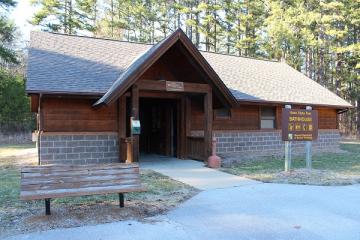 exterior of brick and wood showerhouse with bench in front