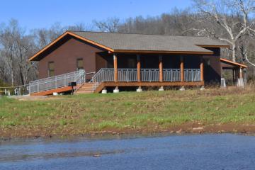 Exterior image of a cabin with brown siding and covered front porch.