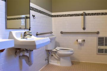 View of bathroom with toilet, vanity and mirror.