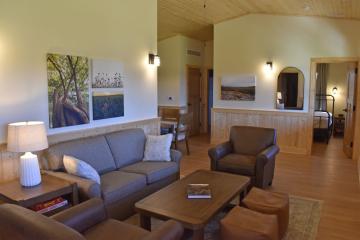View of living room with couches, coffee table, side table and lamp.