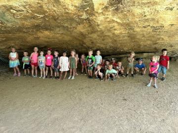 Students pose for a photo inside the mouth of a cave