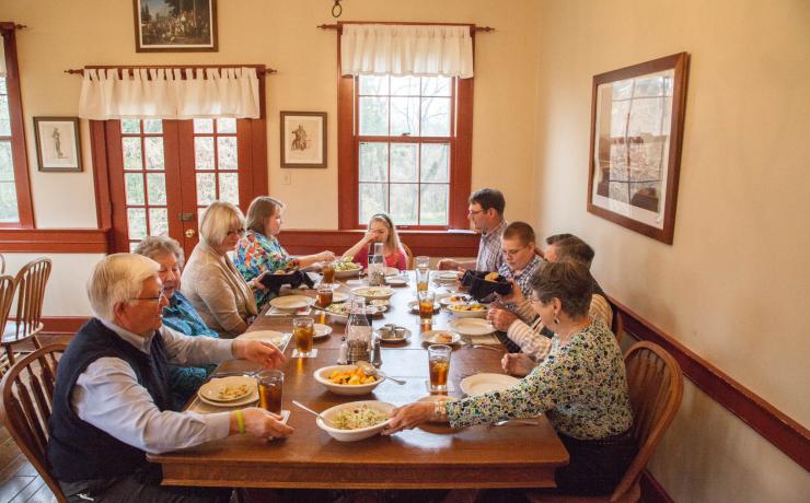 A family eating a dinner at a wood dining table