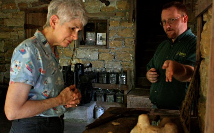A historical site employee showing a woman some of the artifacts on display