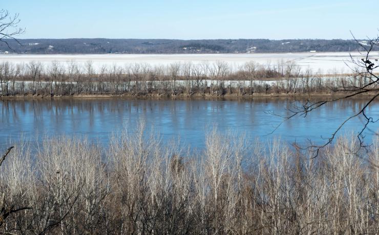 A body of water surrounded by a snow-covered field