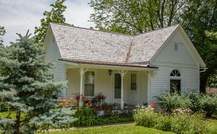 A small white house with flowers out front