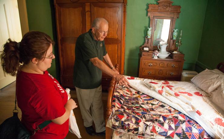 Two people looking at quilts on display