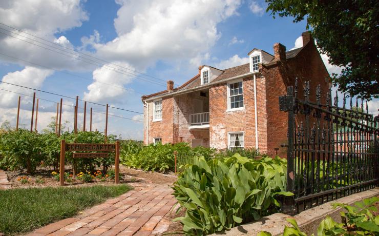A brick building with a sign out front that says Kitchen/Garden
