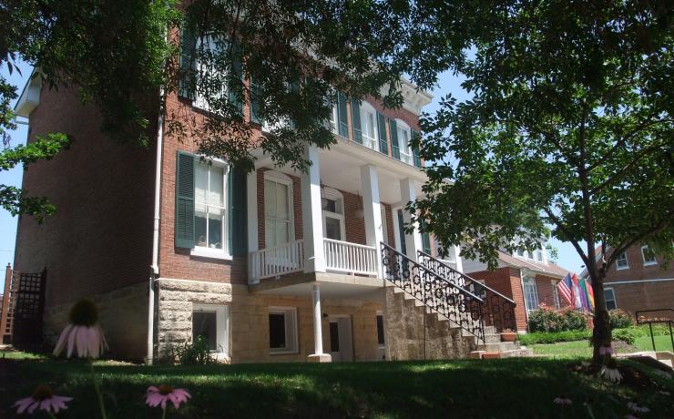 A brick house with purple flowers in front of it