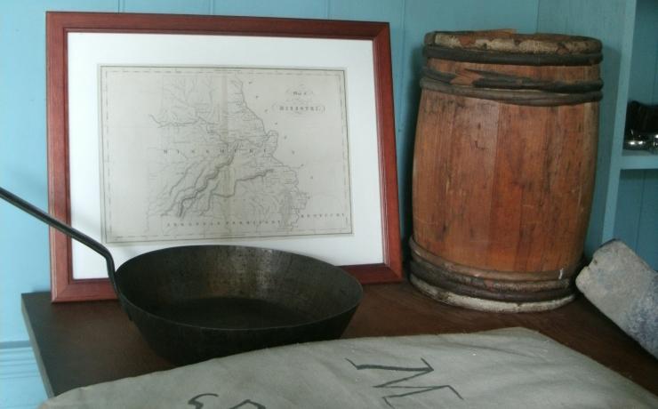 A small table with a pan, a map of Missouri, and a cloth sack