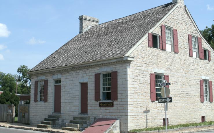A white brick house with red doors and shutters