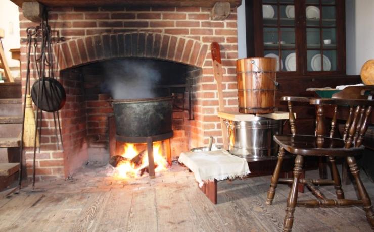 A black pot over a fire in a brick fireplace