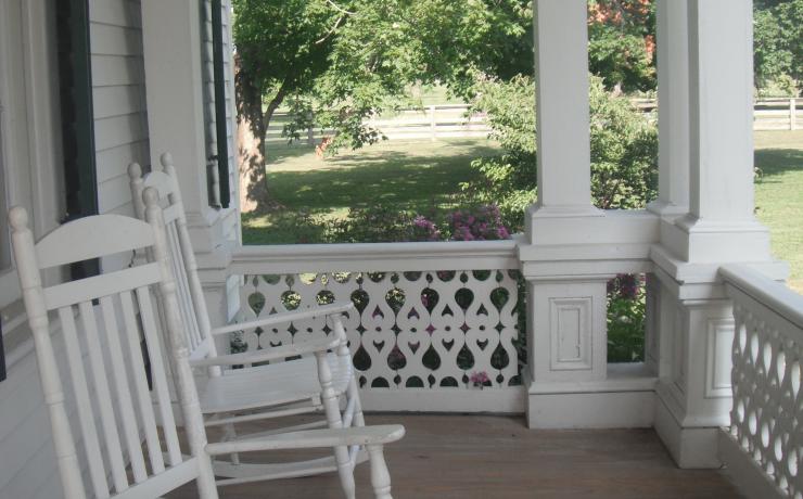 A white rocking chair on a porch