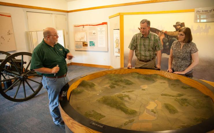 A park ranger showing a model of Missouri fields to two people