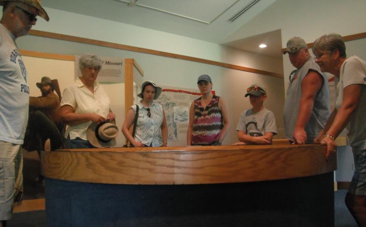A group of people looking at a model of the battle field at the Battle of Pilot Knob