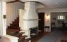 Inside of the Benton home with a white fireplace and stairs leading up