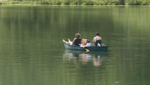 people fishing on a small boat in the middle of a body of water